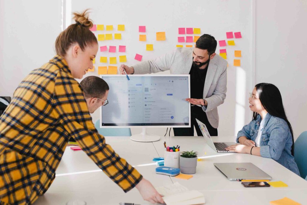 Young entrepreneurs demonstrate the nitty gritty of starting an LLC in Ohio by strategizing with a white board, sticky notes, and a monitor.