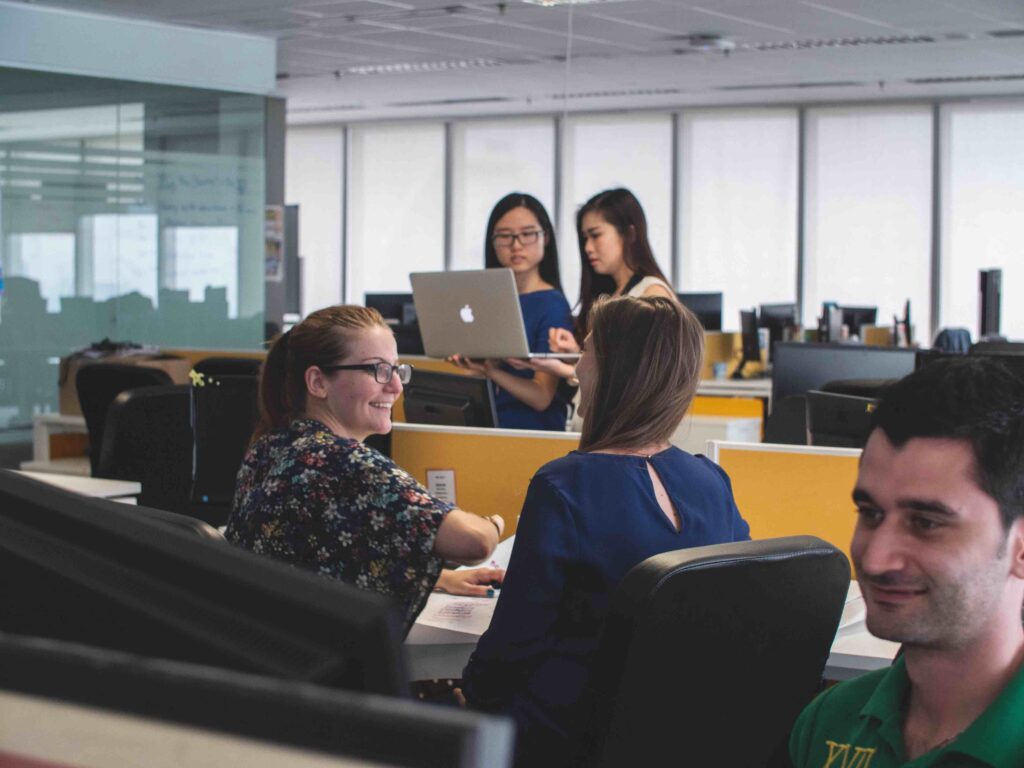 Smiling coworkers in an office show how to start a business in Ohio with friends.